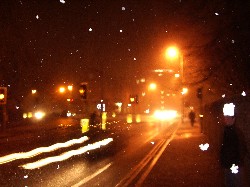 It's snowing! That car looks like it's going backwards, but it's not.